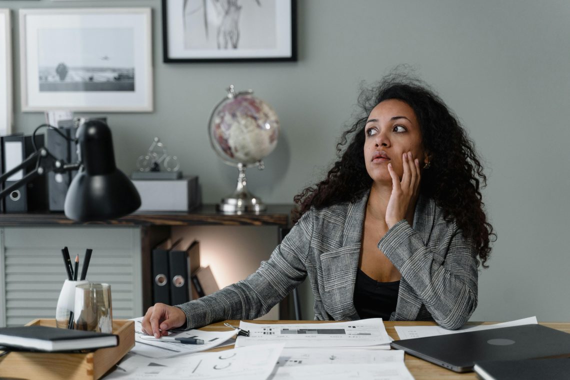 Confident woman smiling while reviewing financial documents, representing overcoming money shame and building financial empowerment