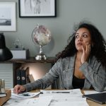 Confident woman smiling while reviewing financial documents, representing overcoming money shame and building financial empowerment