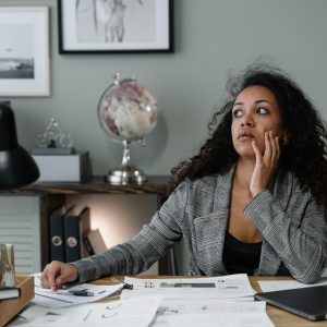 Confident woman smiling while reviewing financial documents, representing overcoming money shame and building financial empowerment