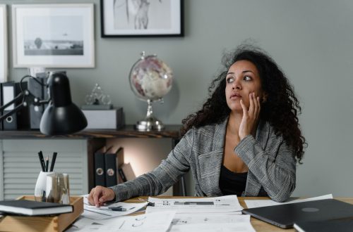Confident woman smiling while reviewing financial documents, representing overcoming money shame and building financial empowerment