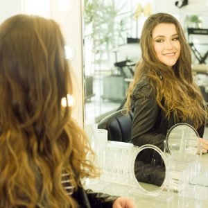 Woman admiring herself in a mirror - symbolizing reclaiming your identity as a mom.